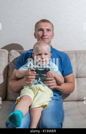 Kind Junge und sein Vater spielen mit einer Playstation zusammen. Stockfoto