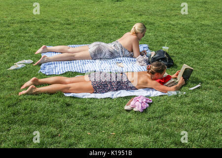 London, Großbritannien. 25 Aug, 2017. 2 Frauen lesen auf dem Gras, wie Sie die Rückkehr der warmen Wetter im Green Park auf einem herrlichen sonnigen Tag in London Kreditkarte geniessen: Amer ghazzal/Alamy leben Nachrichten Stockfoto