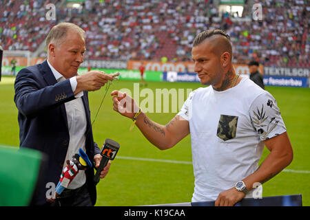 26.08.2017, Fussball 1. Liga 2017/2018, 2. Spieltag, FC Augsburg - Borussia Mönchengladbach, in der Wwk-Arena Augsburg. Ex-Augsburger Raul Bobadilla (re, Gladbach) wird vom FCA mit Figur aus der Augsburger Puppenkiste (Jim Knopf) verabschiedet, li: Sportdirektor Stefan Reuter (FC Augsburg) Foto: Cronos/MIS Stockfoto