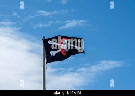 Piratenflagge flatterte in einem blauen Himmel Stockfoto