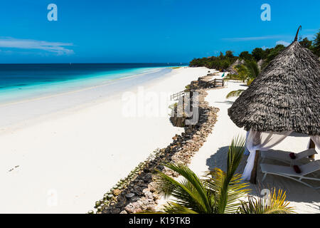 Schöner Strand durch das blaue Wasser des Indischen Ozeans in Sansibar. Sansibar ist eine Insel an der Küste von Tansania - Afrika. Stockfoto