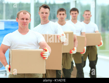Team von Bauherren mit Boxen von Baustoffen Stockfoto