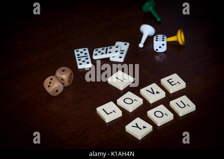 Wort Fliesen, buchstabieren Sie "ICH LIEBE DICH", verschiedene Brettspiele Utensilien ist in der Nähe. Stockfoto