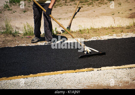 Nivellierung frischen Asphalt auf dem kleinen Weg. Asphalt, Verlegung, Straßenreparatur. Stockfoto