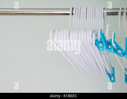 Die Gruppe der neue Kunststoff Kleiderbügel auf dem Metall in der Nähe der Wand in der Wäscherei service. (Wählen Sie Fokus) Stockfoto