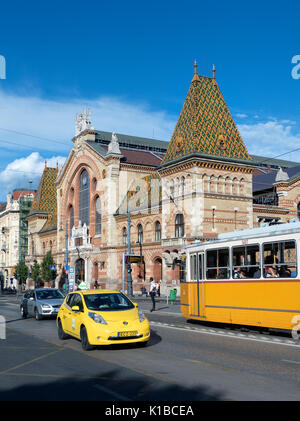 Budapest, Ungarn - 10. Juni 2017: Die Außenseite des Nagycsarnok - der große zentrale Markt in Budapest - mit einer Straßenbahn vorbei Stockfoto