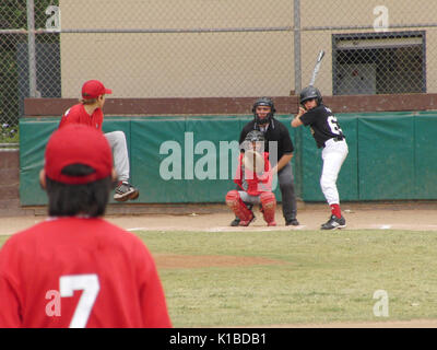 Teamarbeit. Baseball Team von Jugend in Aktion. Pitcher's Bewegung. Der Hitter schwingen. Blickfang auf Position. Stockfoto