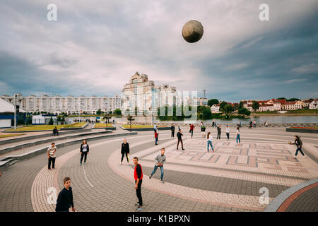 Minsk, Weißrussland - Juni 28, 2017: Jugendliche Ball spielen auf dem Hintergrund des neuen Wolkenkratzers Wohnanlage am Trinity Trinity Hill. Stockfoto