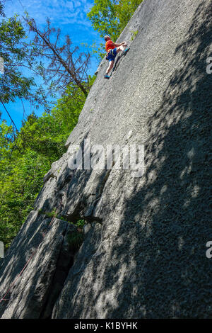 Erfahrene männliche Kletterer in Rot auf glatten Felswand, in der Nähe von Reutte, Austris Stockfoto