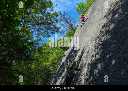 Erfahrene männliche Kletterer in Rot auf glatten Felswand, in der Nähe von Reutte, Austris Stockfoto