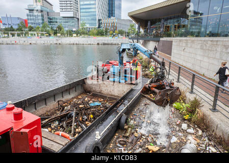 Müllsammelboot auf dem Manchester Ship Canal; HIAB auf einem Lastkahn, der weggeworfene Plastikmüll, Abfall, Abfall, verschmutzt, Verschmutzung, Polystyrol und giftiger Müll, der von den Ufern der Kanäle in Salford Quays and Trafford, Greater Manchester, England, entfernt wird. VEREINIGTES KÖNIGREICH Stockfoto