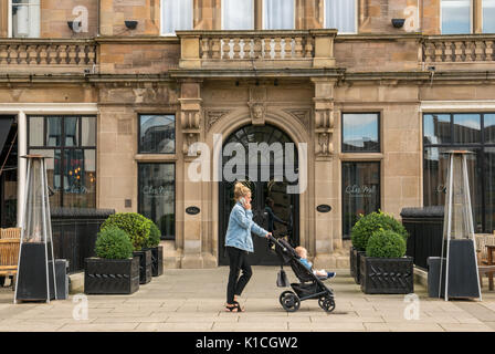 Malmaison Luxus Hotel und Restaurant Chez Mals Brasserie Bar, Leith, Edinburgh, Schottland Großbritannien mit junge Frau Gespräch am Handy drücken und Buggy Stockfoto