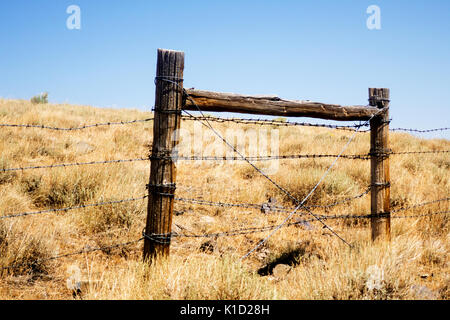 Ein stacheldraht Abschnitt post auf einer einsamen Hügel in Utah. Stockfoto