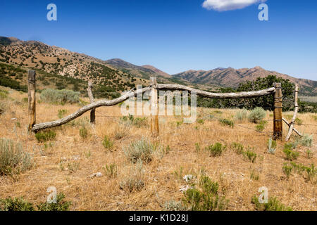 Eine große Stacheldraht hölzernen Pfosten" in der Wüste von Utah mit den Bergen dahinter. Stockfoto