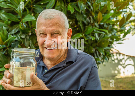 Alter Mann mit Krug Geld Stockfoto