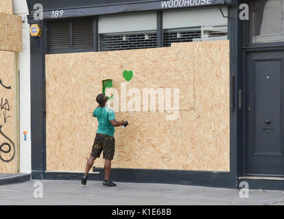 Westbourne Grove, London, UK. 26 Aug, 2017. Ein Mann (eine von vielen sagte Er) Spritzen der Grünen grüne Herzen Grenfell' auf der Geschäfte entlang der Karneval Route bestiegen werden. Quelle: Matthew Chattle/Alamy leben Nachrichten Stockfoto