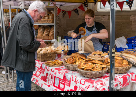 Dock Place, Leith, Edinburgh, Schottland, Großbritannien. Garküche in Leith Farmers Market, der findet jeden Samstag. Mann kaufen Pain au Raisin von Au Gourmand Brot Abschaltdruck Stockfoto