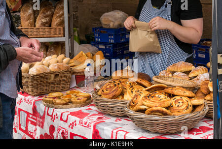 Dock Place, Leith, Edinburgh, Schottland, Großbritannien. Garküche in Leith Farmers Market, der findet jeden Samstag. Mann kaufen Pain au Raisin von Au Gourmand Brot Abschaltdruck Stockfoto