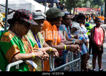 London, Großbritannien. 27 Aug, 2017. Karneval - goers beobachten 3 Schweigeminute für die Opfer der Grenfell Turm Feuer zu ehren. Credit: Bettina Strenske/Alamy leben Nachrichten Stockfoto