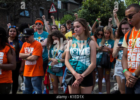 London, Großbritannien. 27 Aug, 2017. Karneval - goers beobachten 3 Schweigeminute für die Opfer der Grenfell Turm Feuer zu ehren. Credit: Bettina Strenske/Alamy leben Nachrichten Stockfoto