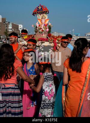 Worthing, Großbritannien. 27. August 2017. Ganesh-Festival in Großbritannien - Mitglieder der lokalen Hindu-Gemeinde tragen ein Modell von Lord Ganesh entlang der Strandpromenade zum Ärmelkanal. Auch bekannt als Ganesh Chaturti, feiert das wichtige Fest den Elefantenköpfigen Sohn von Herrn shiva und Göttin Parvati, ein Symbol für Weisheit, Wohlstand und Glück. Das Modell ist aus Gips von paris gefertigt und löst sich im Meerwasser auf. Quelle: Foto: Jonathan Eastland/Ajax/Alamy Live News Stockfoto