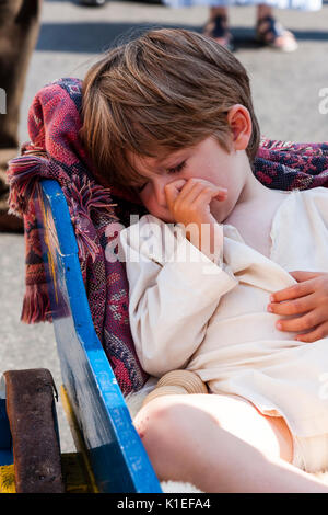 England. Junge Junge, zwei bis drei Jahre alt, schläft die Verlegung in die Hand Warenkorb im Schatten an einem heißen Sommertag. Daumen in den Mund. Stockfoto