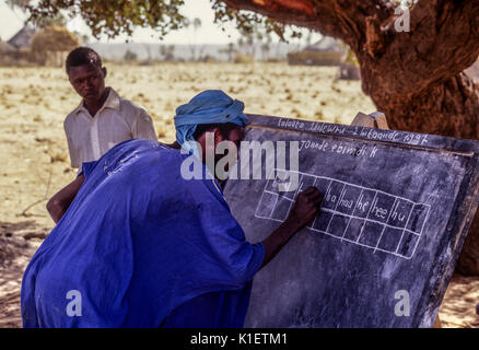 Niger, Doutouel Village, West Afrika. Man üben das Schreiben in die Alphabetisierung von Erwachsenen Klasse. Stockfoto