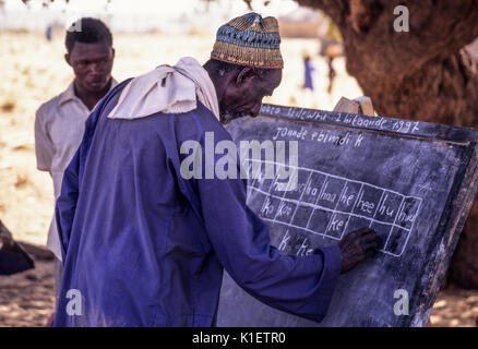 Niger, Doutouel Village, West Afrika. Man üben das Schreiben in die Alphabetisierung von Erwachsenen Klasse. Stockfoto