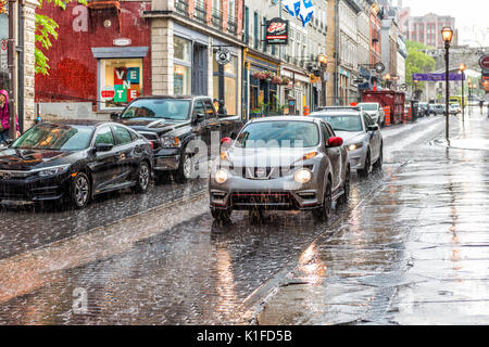 Quebec City, Kanada - 31. Mai 2017: Altstadt Straße Saint-Jean bei starkem Regen mit Tropfen und nasse Straße, Auto Stockfoto