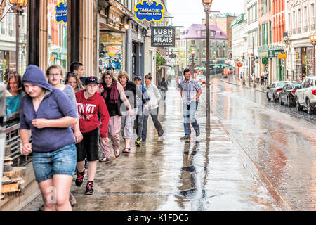 Quebec City, Kanada - 31. Mai 2017: Altstadt Straße Saint-Jean bei starkem Regen mit Tropfen und Menschen auf der Suche nach Unterschlupf Stockfoto