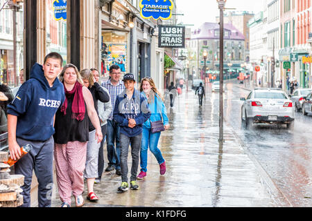 Quebec City, Kanada - 31. Mai 2017: Altstadt Straße Saint-Jean bei starkem Regen mit Tropfen und Menschen auf der Suche nach Unterschlupf Stockfoto