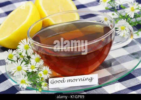 Guten Morgen Karte mit Tasse Tee, Kamille Blumen und frische Zitrone Stockfoto