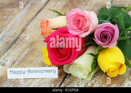 Herzlichen Glückwunsch zum Jubiläum Karte mit bunten Blumenstrauß aus Rosen auf Holzmöbeln im Landhausstil Oberfläche Stockfoto