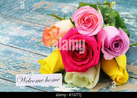 Willkommen Home Karte mit bunten Rose Bouquet auf Holzmöbeln im Landhausstil Oberfläche Stockfoto