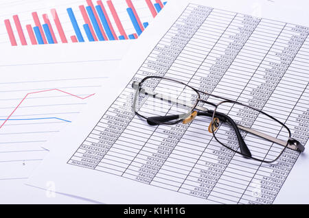 Finanzielle Papier Diagramme und Grafiken und Gläser. Geschäftsberichte und Stapel von Dokumenten. Stockfoto