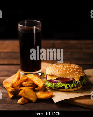 Hamburger, Pommes und Cola trinken auf einem dunklen Hintergrund Stockfoto