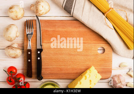 Trockene Pasta mit Gemüse, Pilzen, Käse und Tomaten auf rustikalen Hintergrund. Platz für Text Stockfoto