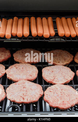Hamburger Frikadellen und Hot Dogs Kochen auf einen neuen Gasgrill Stockfoto