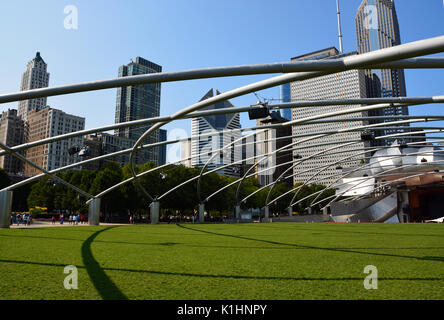 Der Rasen an den Jay pritzker Pavilion in Millennium Park, mit der Chicago Downtown Skyline oben auftaucht, ist ein beliebter Ort für Musik. Stockfoto