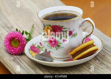 Tasse schwarzen Tee in vintage Porzellan Tasse mit japanischen Cookie und daisy flower Stockfoto
