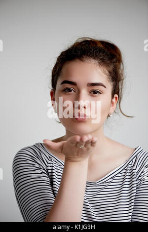 Cute reizende junge Frau stehen und Senden von Kiss über weißen Hintergrund. Flying Kiss, Frau in der Liebe. Stockfoto