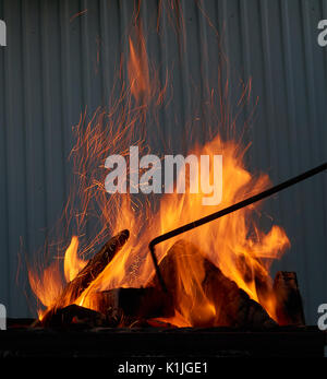 Rot und Orange knisterndes Feuer, die bei der Verbrennung von Holz in den Grill im Freien Stockfoto