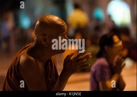 Ein älterer Mönch betet im Heiligen Buddhismus Website der Shwedagon Pagode, Yangon, Myanmar. Stockfoto