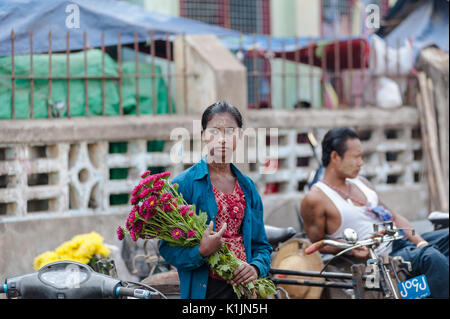 Lokale Frau hält ein Bündel von Blumen auf dem lokalen Markt in Hpa-an, Karen Staat, Myanmar. Stockfoto