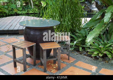 Tisch und Stühle in einem wunderschönen Garten. Raucherbereich. Gartenmöbel Stockfoto