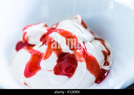 Weiche Vanille Eis mit roten Erdbeersauce closeup dienen in der Schüssel Stockfoto