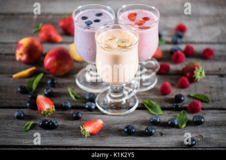 Nahaufnahme der Milchshakes in Gläsern und frische Früchte auf hölzernen Tischplatte Stockfoto