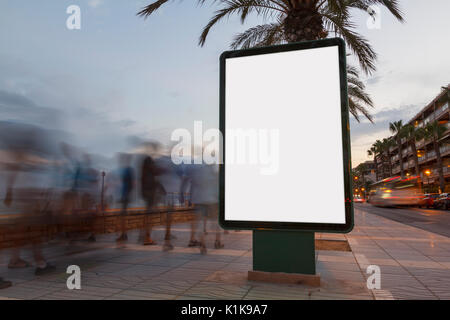 Leere Plakatwand in einen Fußweg bei Sonnenuntergang, mit unscharfen Menschen zu Fuß Stockfoto