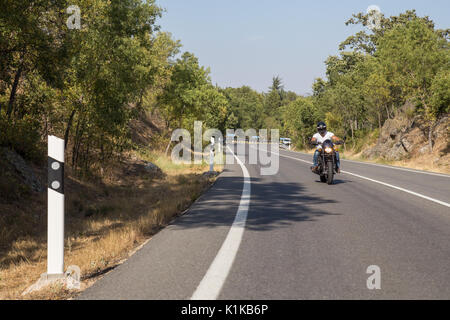 Junger Mann Motorrad fahren auf der Straße in den Bergen in sonniger Tag. Stockfoto