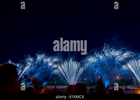 Nicht erkennbare Silhouetten von Menschen sehen und schießen Feuerwerk in der Nacht. Neujahr feiern, Display, festlichen Hintergrund. Platz kopieren Stockfoto